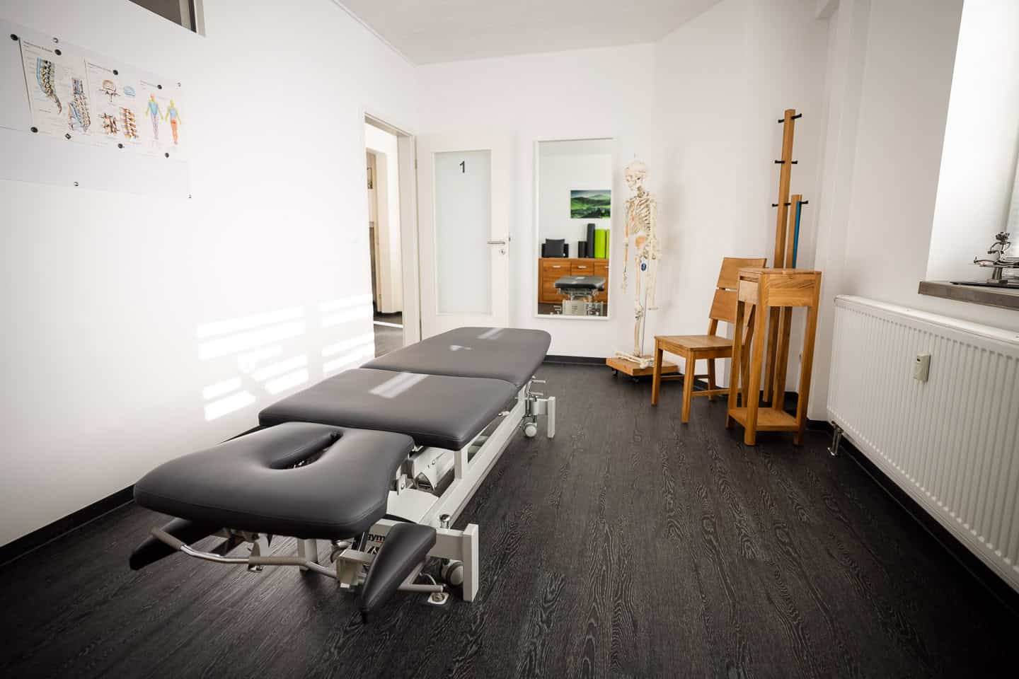 Behandlungsraum bei Physio 360 mit Behandlungsliege und Therapiegeräten.