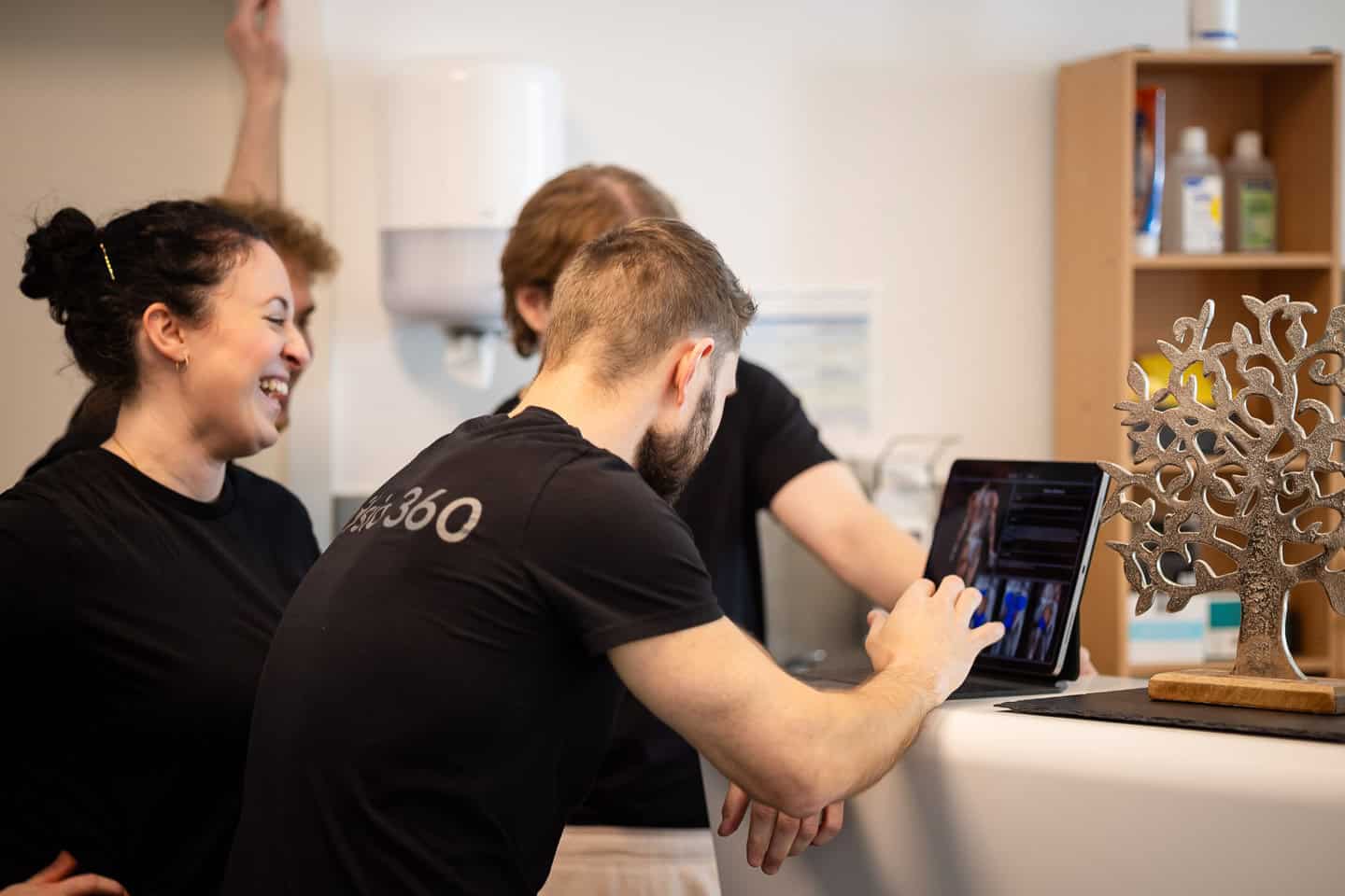 Team bei Physiotherapie in Penzberg, Nutzung digitaler Geräte für Behandlung.