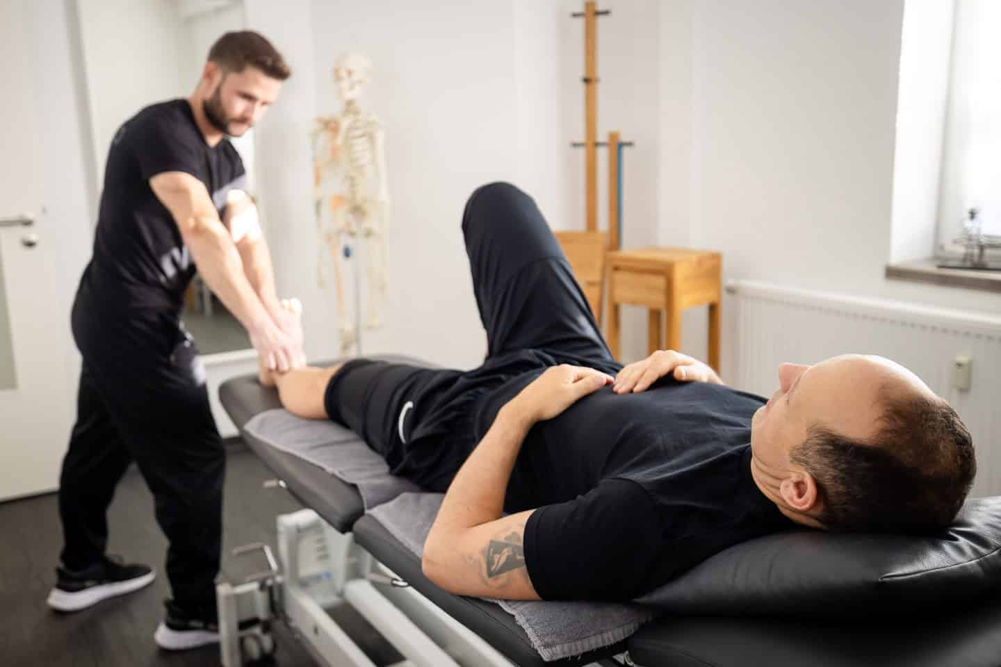 Beinmobilisation bei Physiotherapie in Penzberg, Physiotherapeut behandelt Patient.