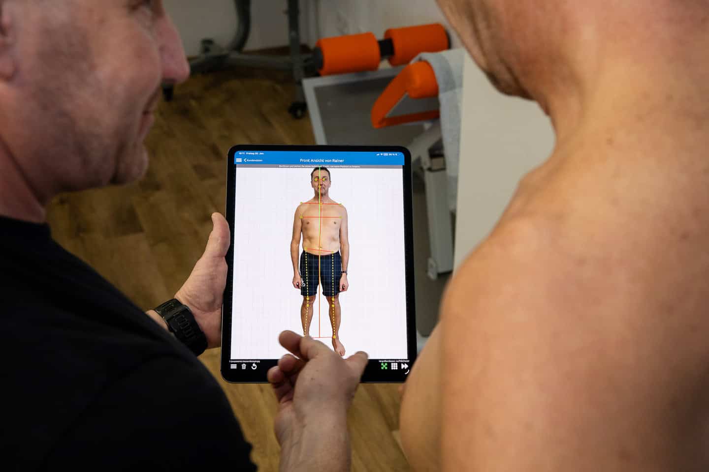 Physiotherapeut zeigt Muskelanalyse auf Tablet bei Penzberg.